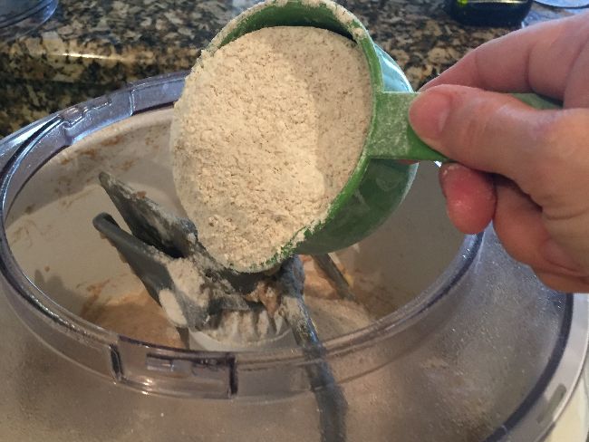 Adding remaining whole wheat flour to mixer bowl
