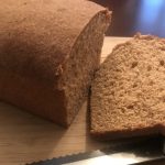 Sliced whole wheat bread loaf on cutting board