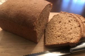 Sliced whole wheat bread loaf on cutting board